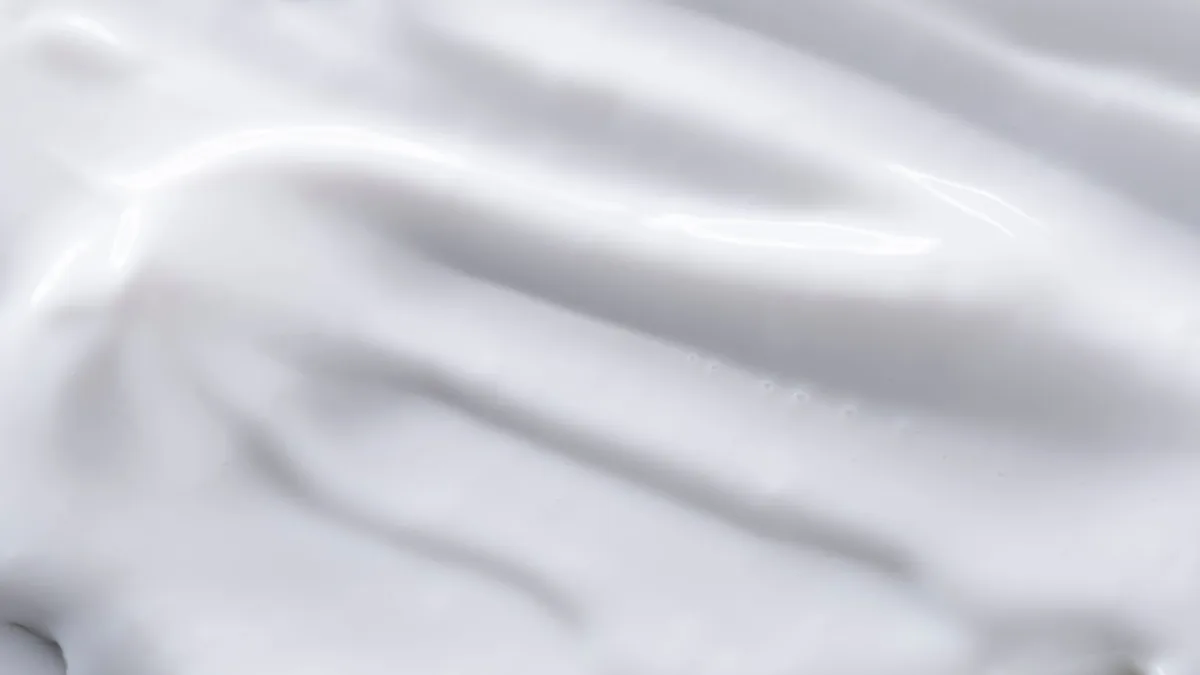 A detailed close-up of a smooth white cream texture, perfect for backgrounds or food imagery.
