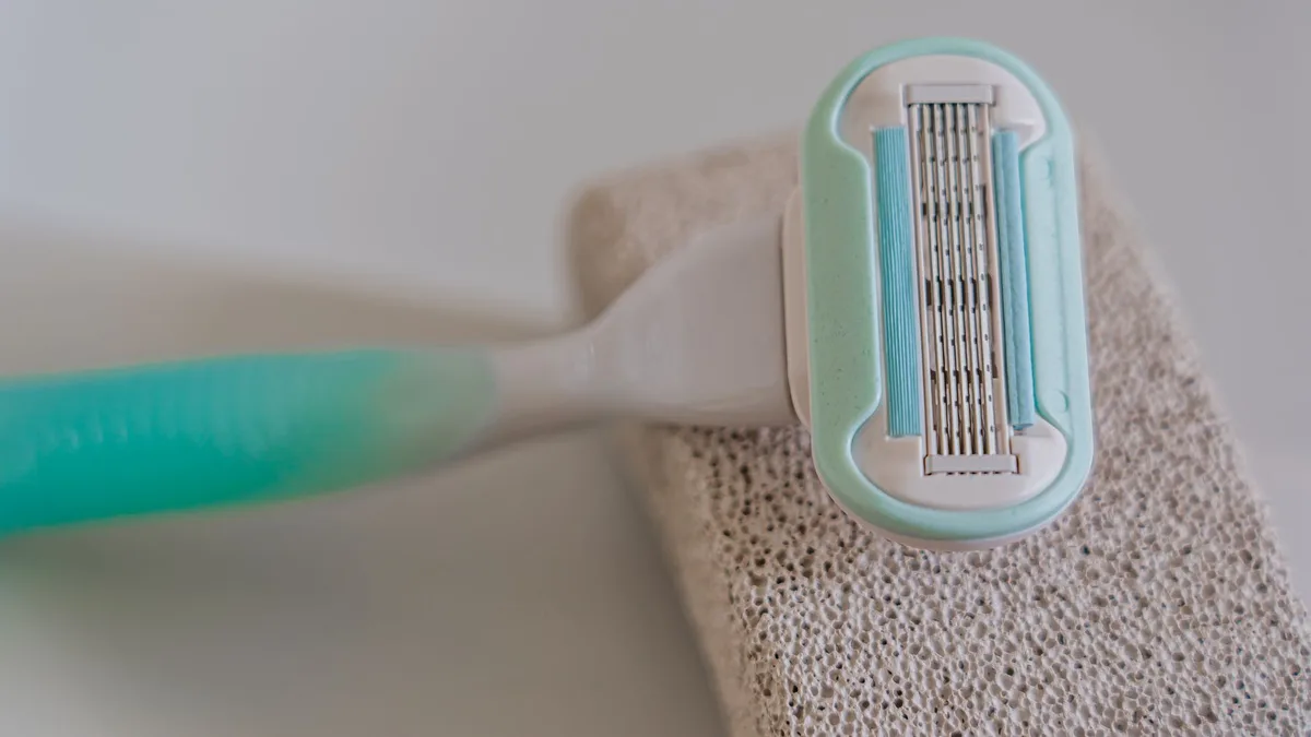 Detailed macro shot of a disposable razor placed on a textured pumice stone.