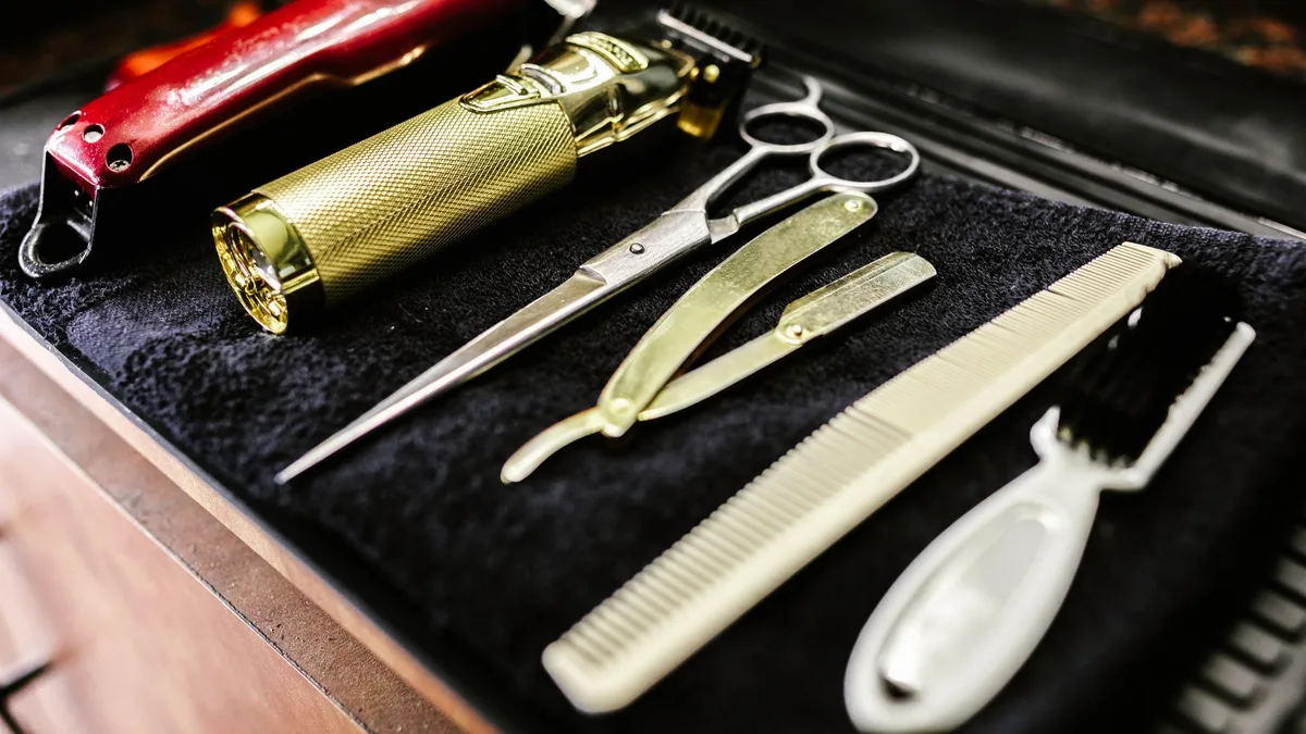 A collection of essential barbershop tools including trimmers, scissors, and razors neatly arranged.