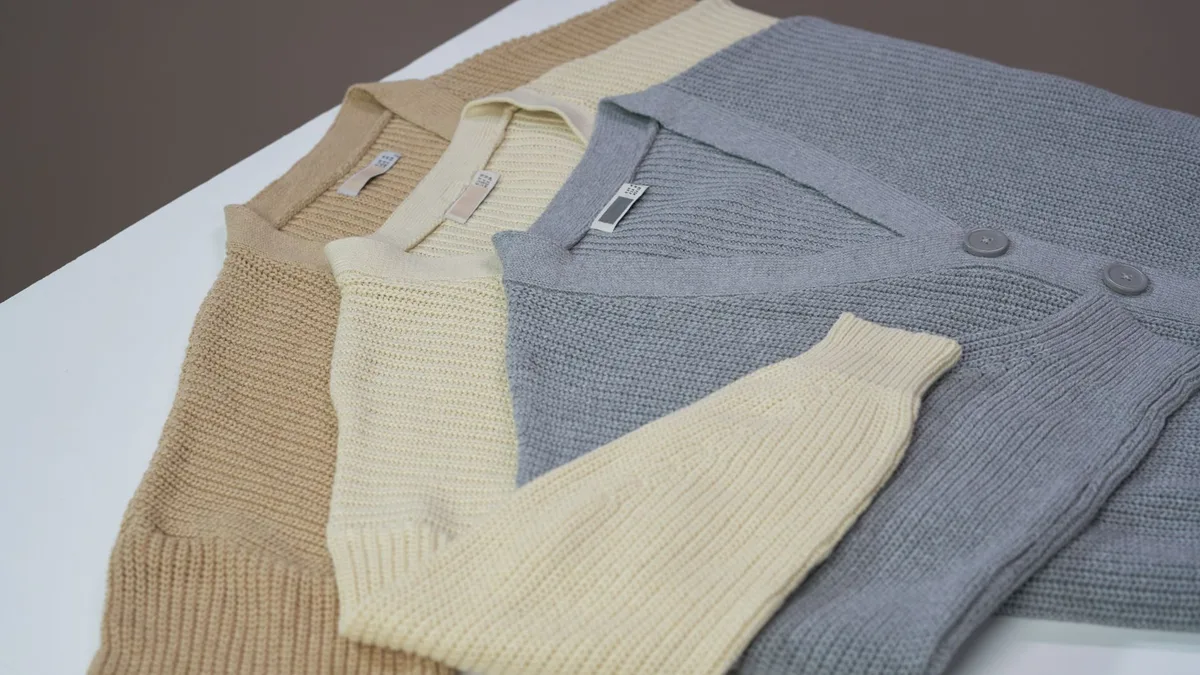 Flatlay of beige, cream, and gray cardigans on a white surface. Perfect for online shopping and fashion catalogs.