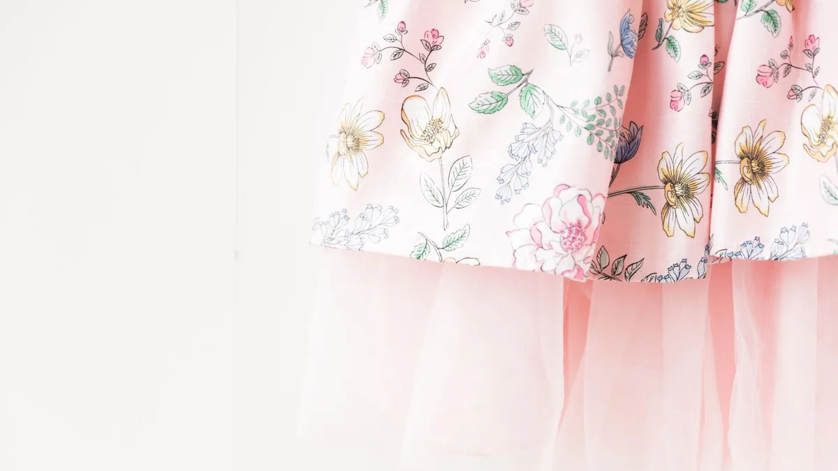 Delicate floral print dress with soft pink tulle layers, perfect for spring fashion.